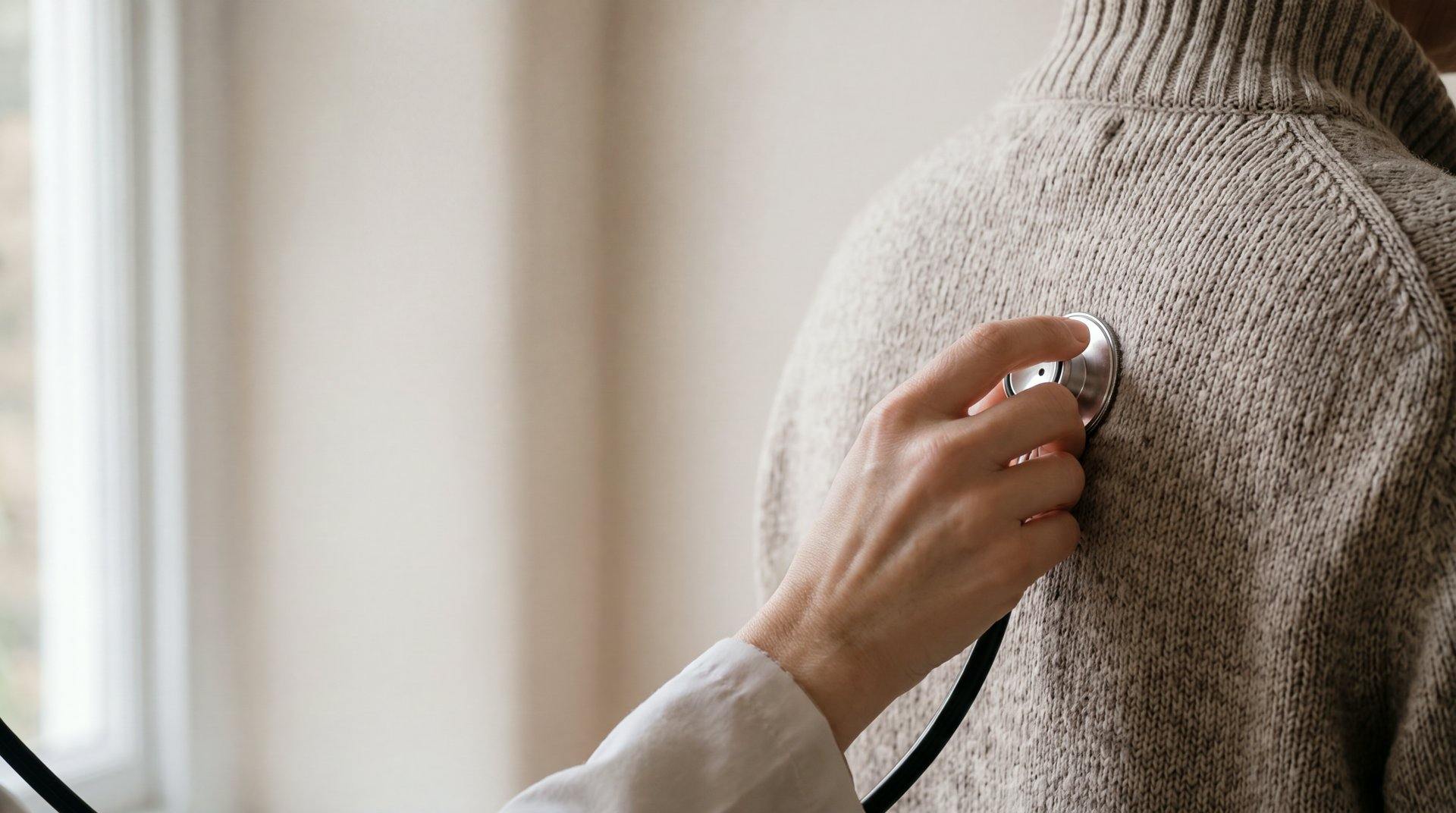 A GP listening with a stethoscope to a patient's back