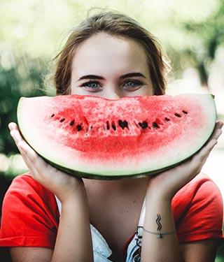 Woman holding slice of watermelon | Meyer Clinic